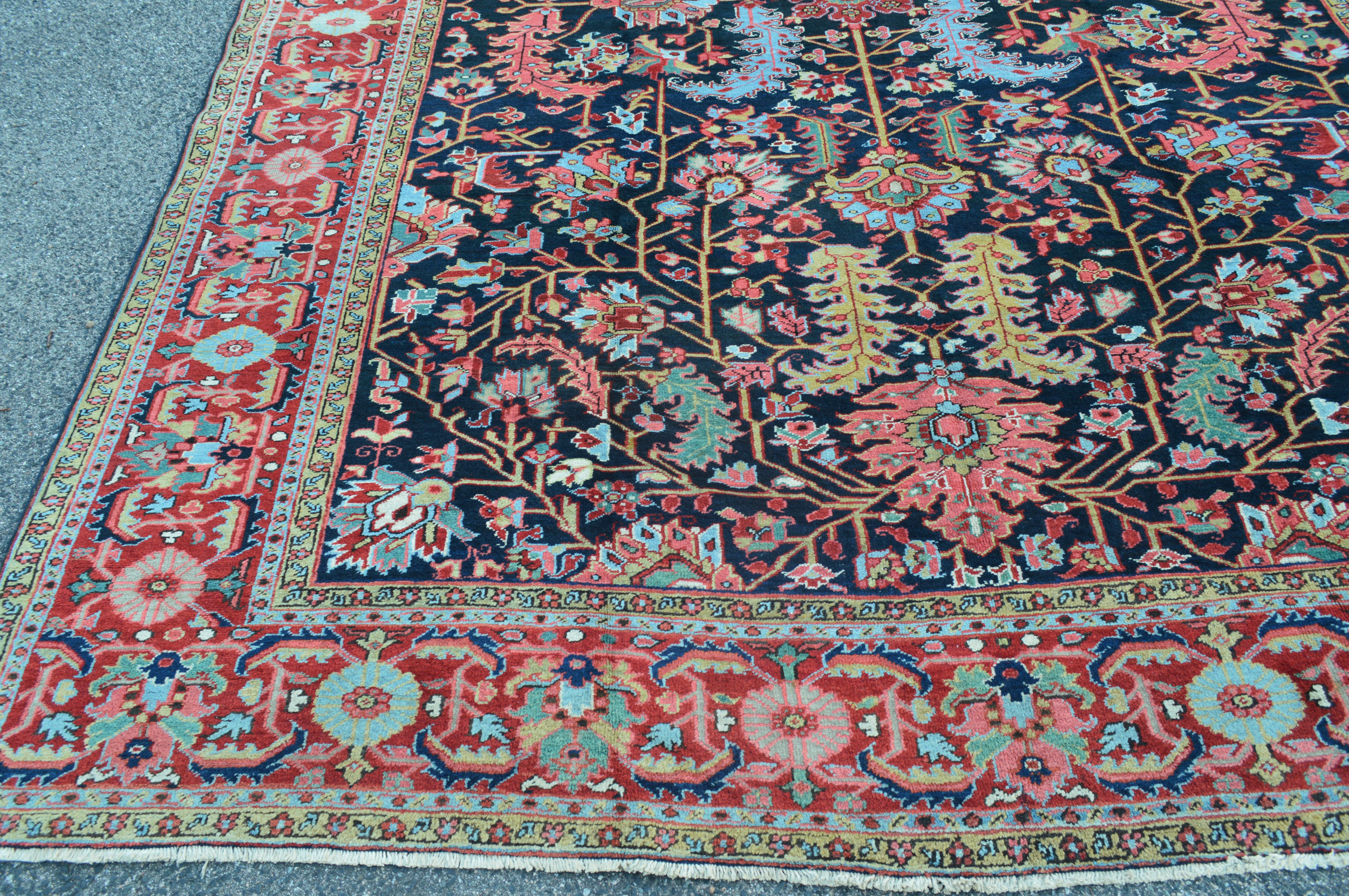 Border and field detail from an antique Persian Heriz carpet with stylized palmettes, leaves and flowers on a navy field with a brick red border - Douglas Stock Gallery, antique rugs Boston,MA area