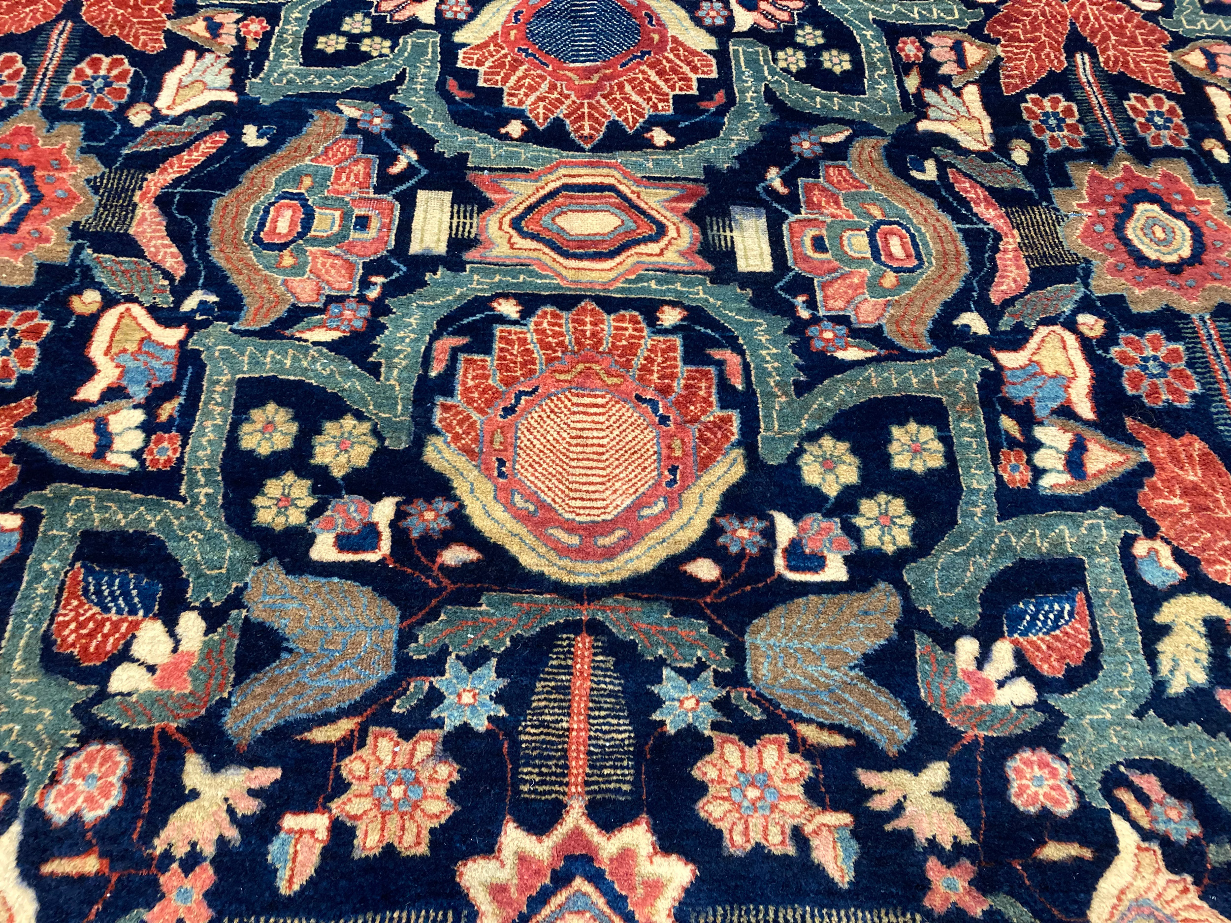 Field detail of an antique Persian Fereghan Sarouk carpet with flowers and strapwork on a navy field