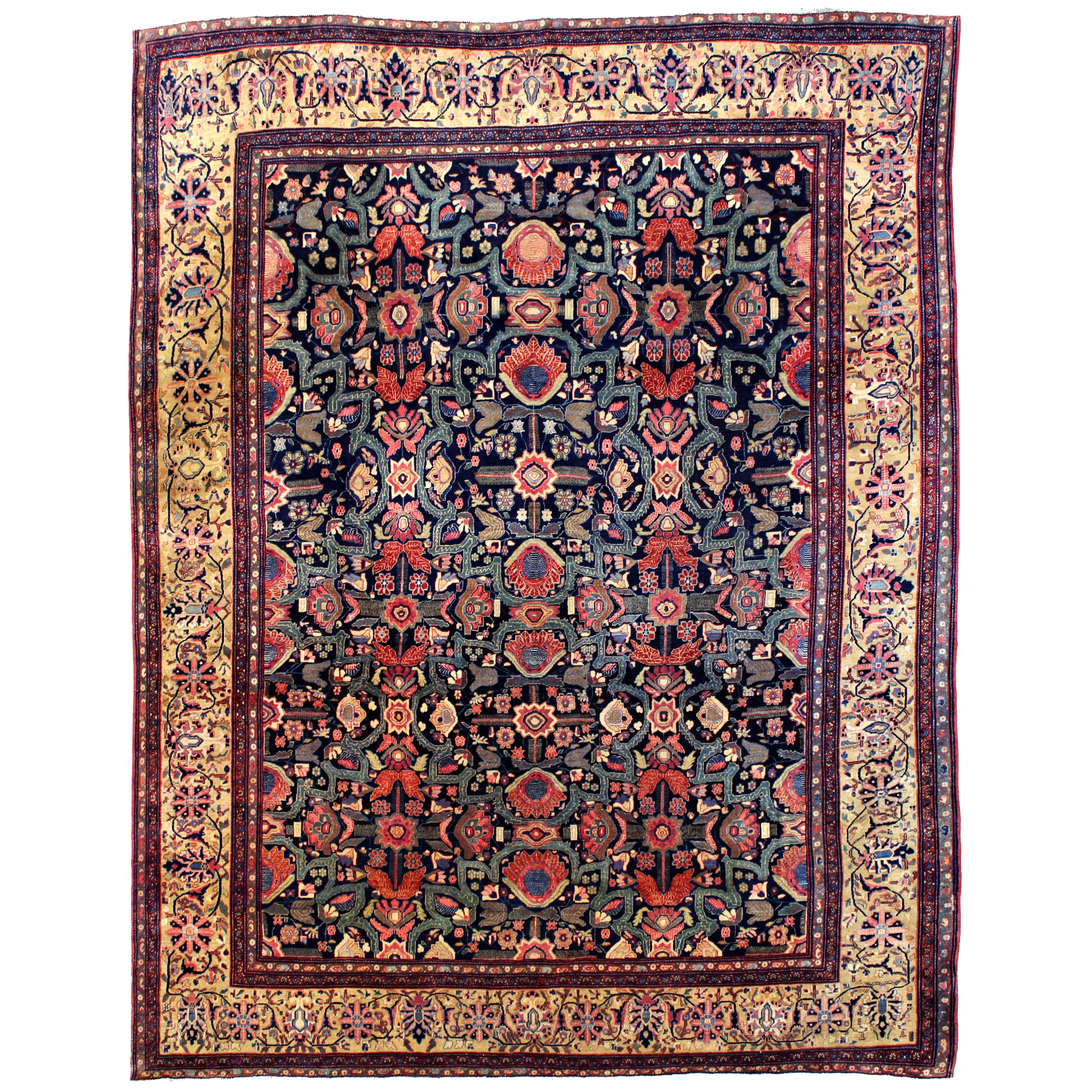 Antique Persian Fereghan Sarouk carpet with a navy blue field decorated with flowers and strapwork and framed by a camel color border
