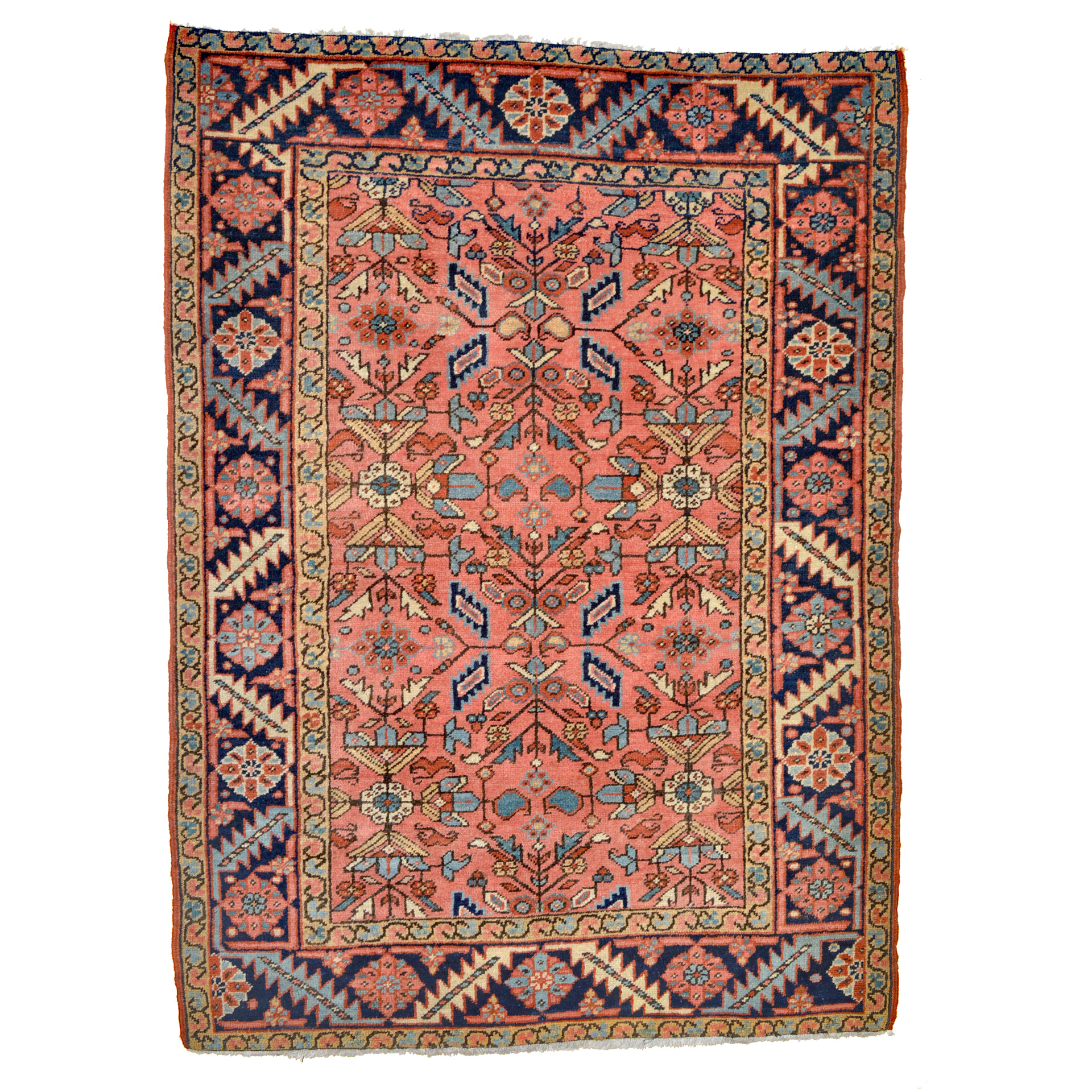 Douglas Stock Gallery offers one of the finest selections of antique Oriental rugs in New England. Based in the Boston area but with clients for antique rugs across the United States, Douglas Stock Gallery offers antique Persian rugs and antique Caucasian rugs across a wide price and style range. An antique Persian Heriz rug measuring approximately 4'5" x 6' and with an uncommon coral color field with an all-over design of stylized leaves and flowers that is framed by a navy blue border, circa 1920.