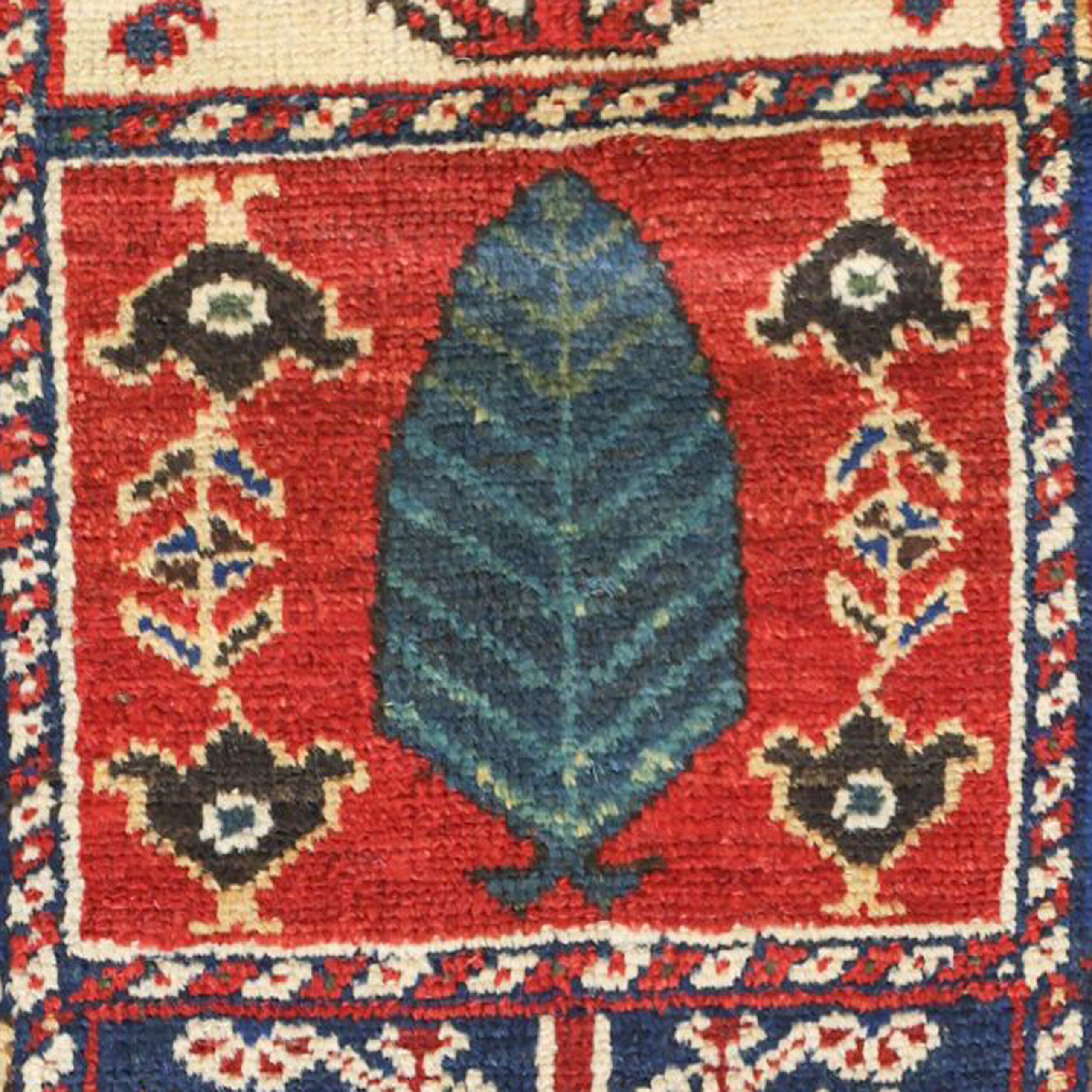 Detail of a teal colored Cypress tree on a madder read background from one of the panels in an antique Persian Bakhtiari tribal carpet with a Garden Panel design, circa 1895. Douglas Stock Gallery offers a selection of antique tribal rugs, carpets and bags, antique rugs Boston,MA area