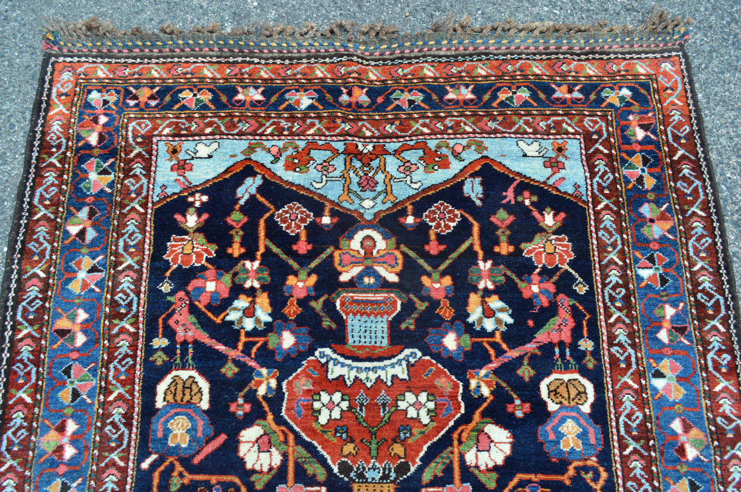 Detail of an antique Persian Bakhtiyari runner with a navy blue field decorated with stylized vases, birds and flowers, Douglas Stock Gallery, antique Oriental runners Boston,MA area