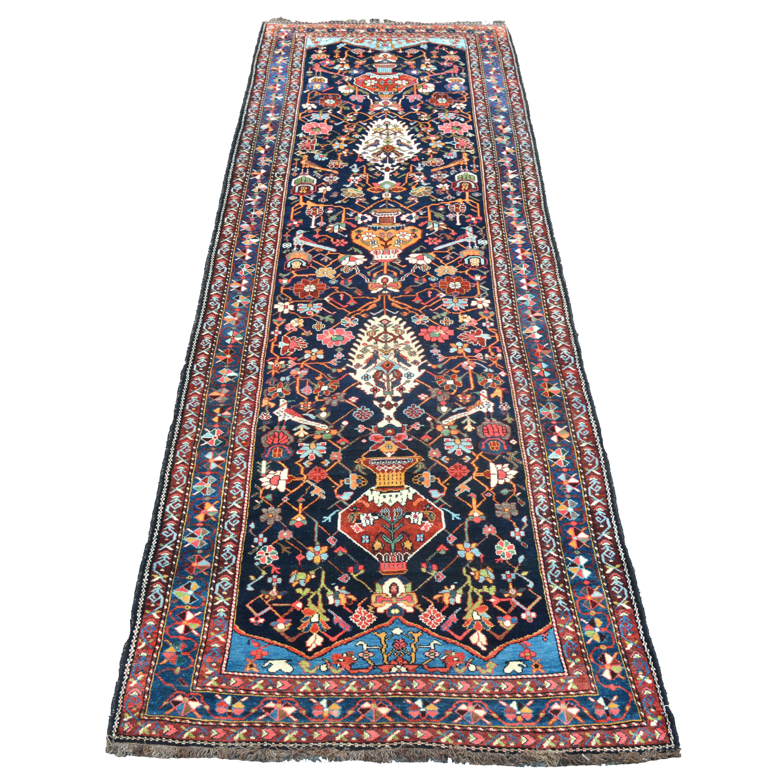 An exceptionally beautiful antique runner woven by the Bakhtiyari tribe in south Persia. The navy field is decorated with stylized flowers, vases and birds, Douglas Stock Gallery, antique Oriental rugs, antique runners, antique carpets Boston,MA area