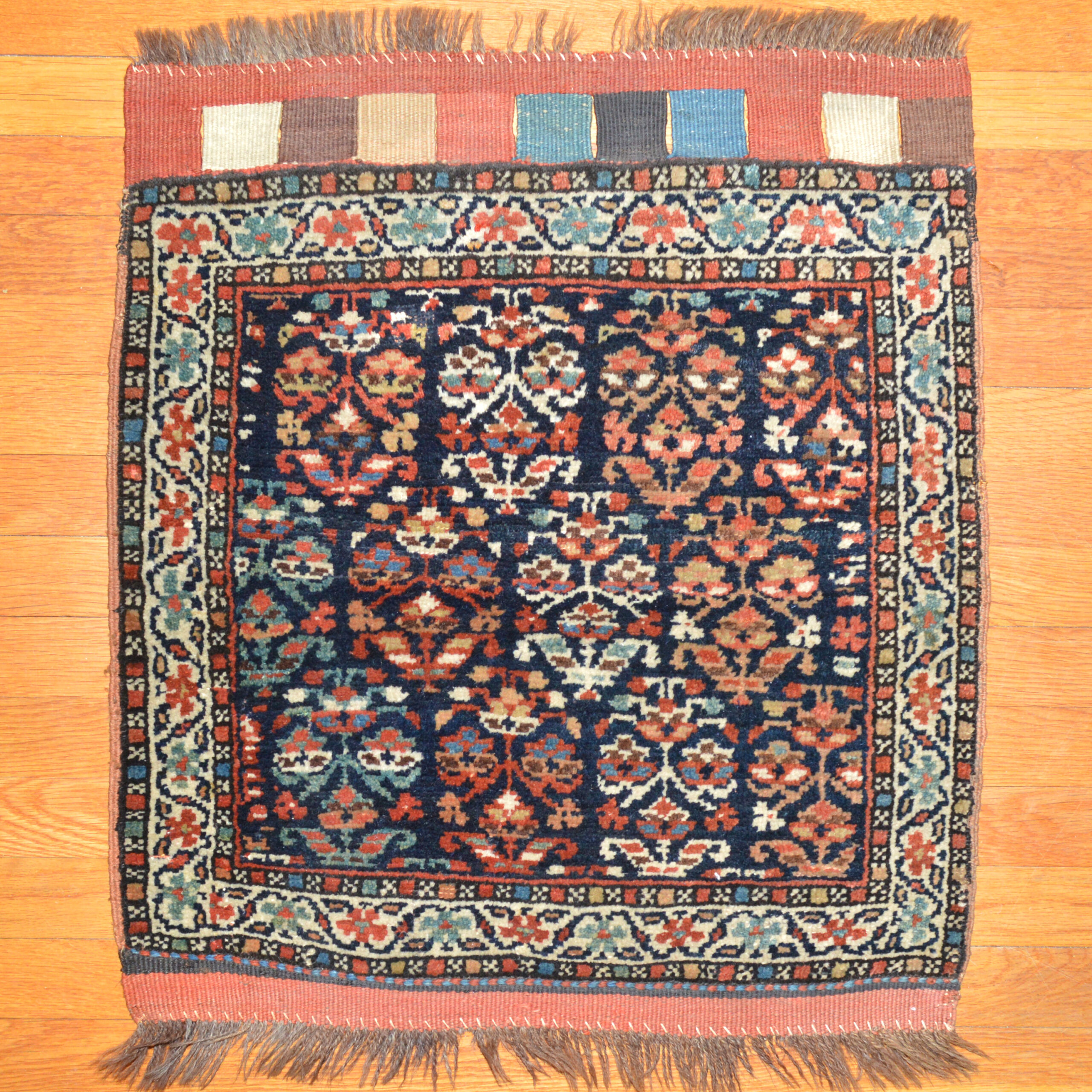 An antique northwest Persian tribal bag face, probably woven by a member of the Shah Savan tribe but possibly Kurdish, circa 1890. The navy blue field is decorated with polychromatic stylized flowers and framed by an ivory scrolling vine and flower border. Douglas Stock Gallery, antique tribal rugs and bags, Boston,MA area New England