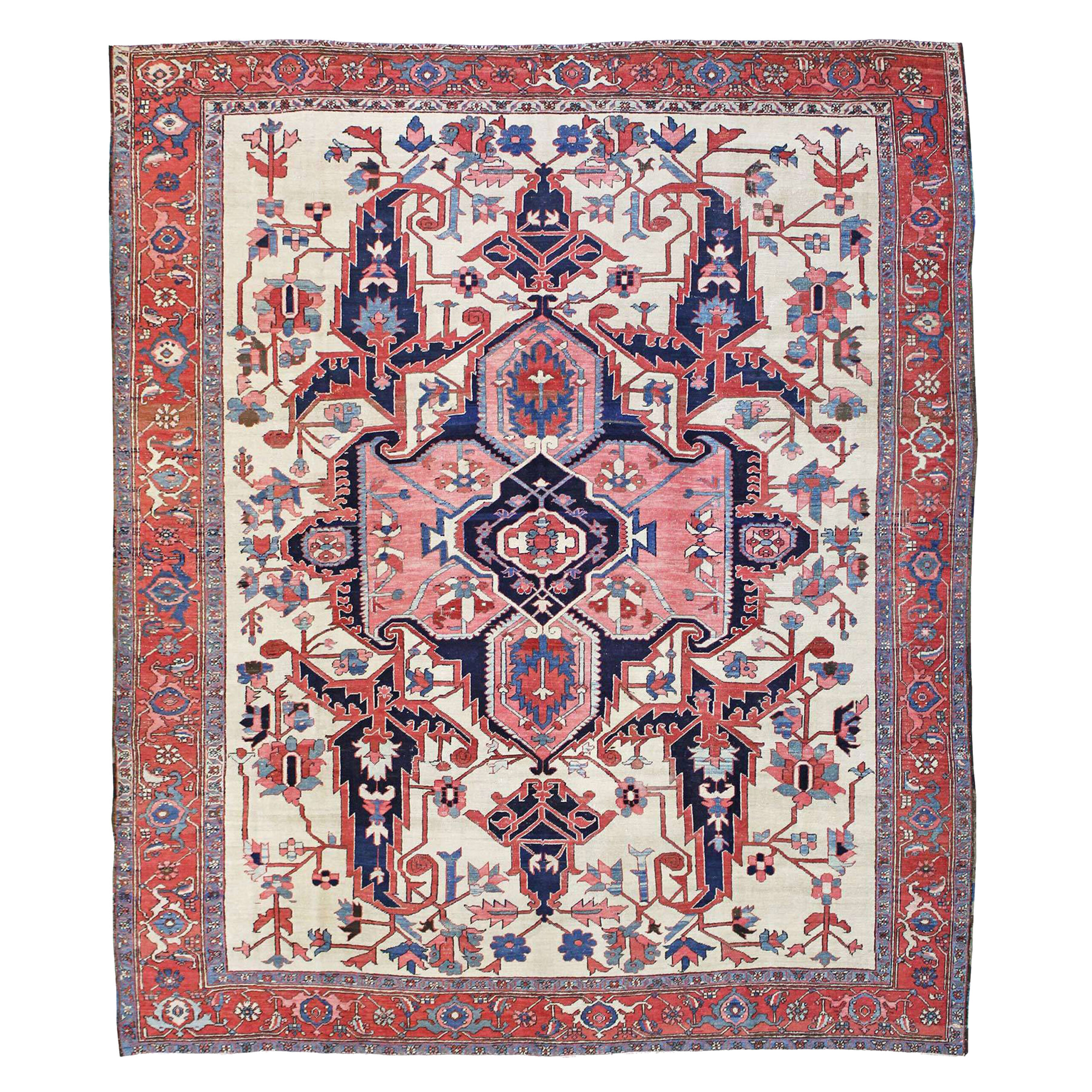 An antique Persian Heriz Serapi carpet with a coral and navy blue medallion on an ivory field that is also decorated with large, navy blue leaves and ancillary stylized floral decoration. A brick red Turtle design border frames the field. Douglas Stock Gallery, antique Persian carpets, Boston,MA area, antique carpets Brookline, Newton, Weston, Belmont, Wellesley, Needham, Natick,MA area