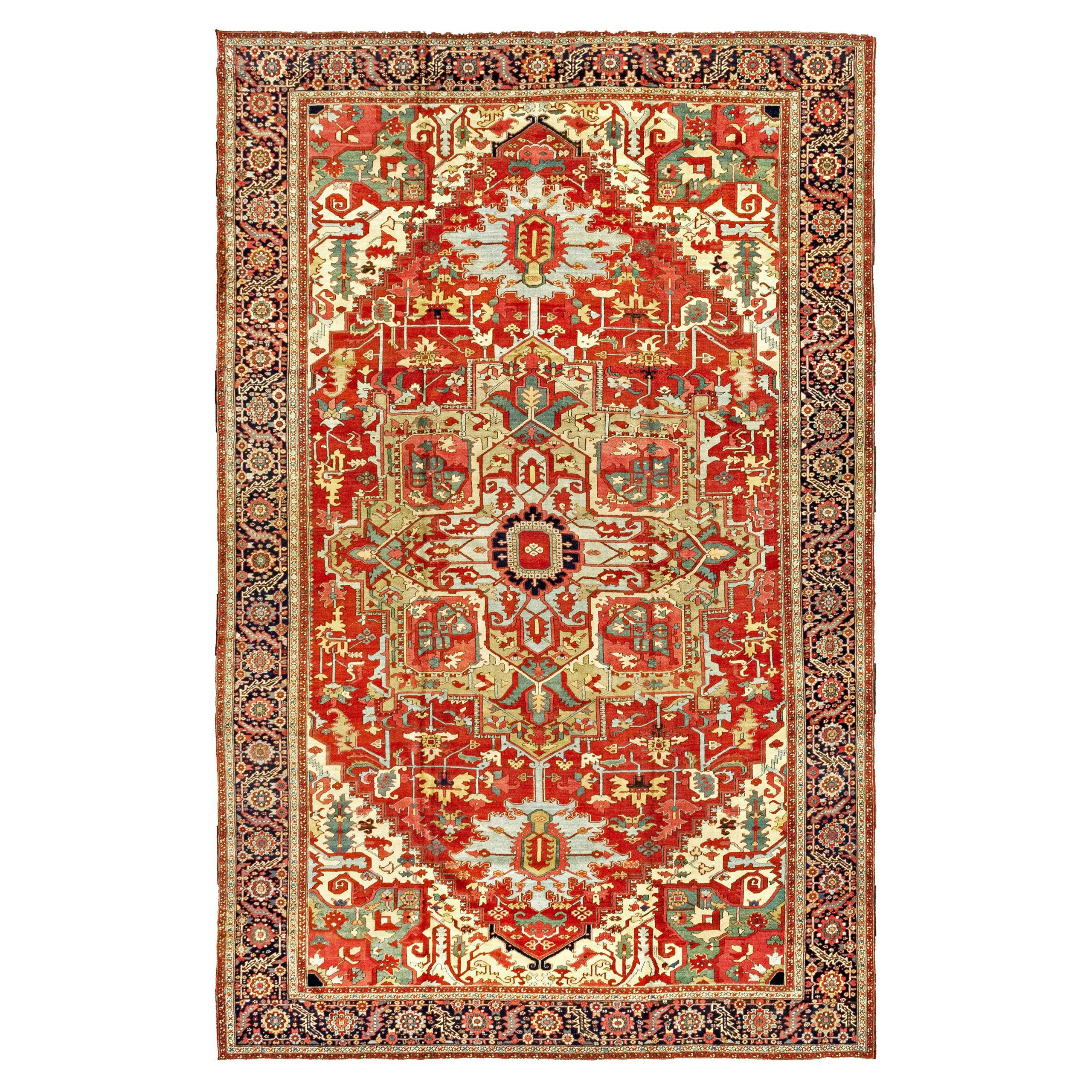 An over size antique Persian Heriz "Serapi" carpet with a grenish-camel medallion with sky blue pendants on a deep salmon color field. Ivory corner spandrels and a navy blue border frame the field, northwest Persia, circa 1900. Douglas Stock Gallery offers on of New England's finest quality selections of antique carpets from the Heriz district in northwest Persia, including antique Heriz carpets, antique "Serapi" carpets, antique Karaja carpets and antique Bakshaish carpets. Antique Heriz "Serapi" carpets Boston,MA area,, antique Heriz "Serapi" carpets NYC by appointment, antique Heriz carpets Washington, DC area by appointment