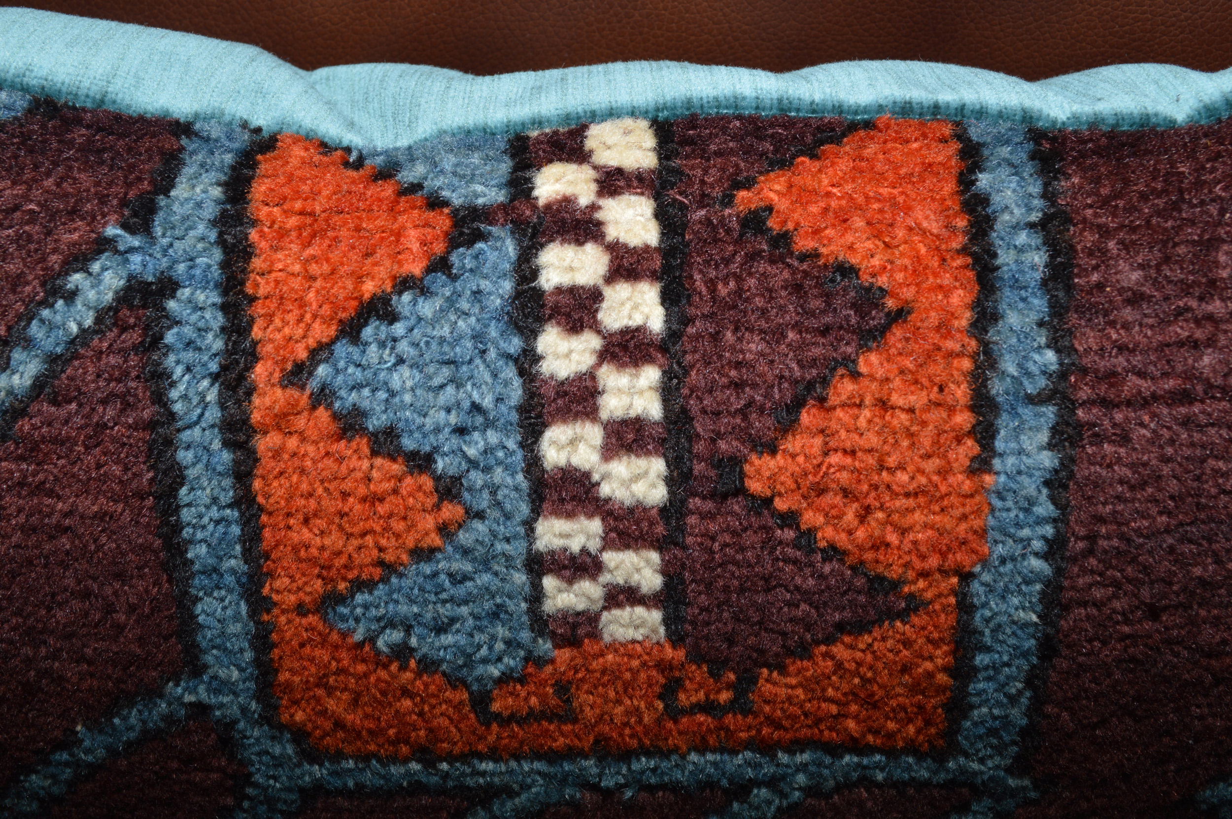 Detail of an antique Turkish rug fragment pillow with deep salmon, light blue, aubergine and ivory colors, Douglas Stock Gallery, antique rug cushions Boston,MA area, antique Oriental rug pillows New England