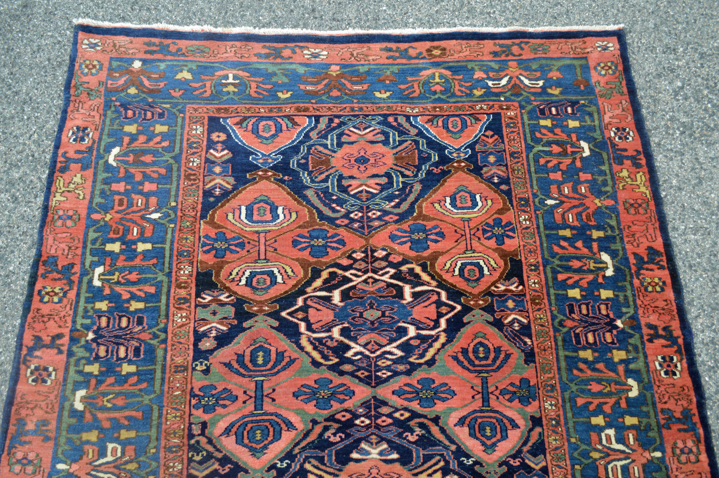 Detail of an antique Persian Bidjar rug with a Quatrefoil design on a navy blue field that is framed by a mid blue, floral border, Douglas Stock Gallery, antique Oriental rugs Boston,MA area New England, antique rugs NYC