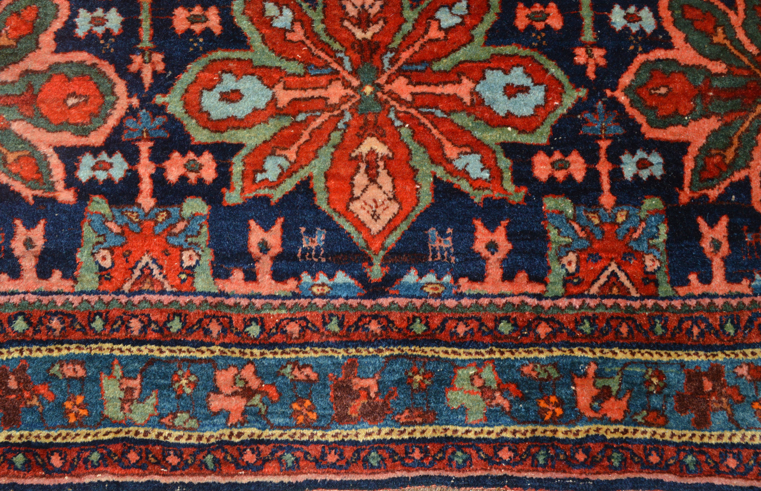 Field and border detail from an antique Persian Bidjar with stylized flowers and animals on a navy blue field, circa 1915 - Douglas Stock Gallery