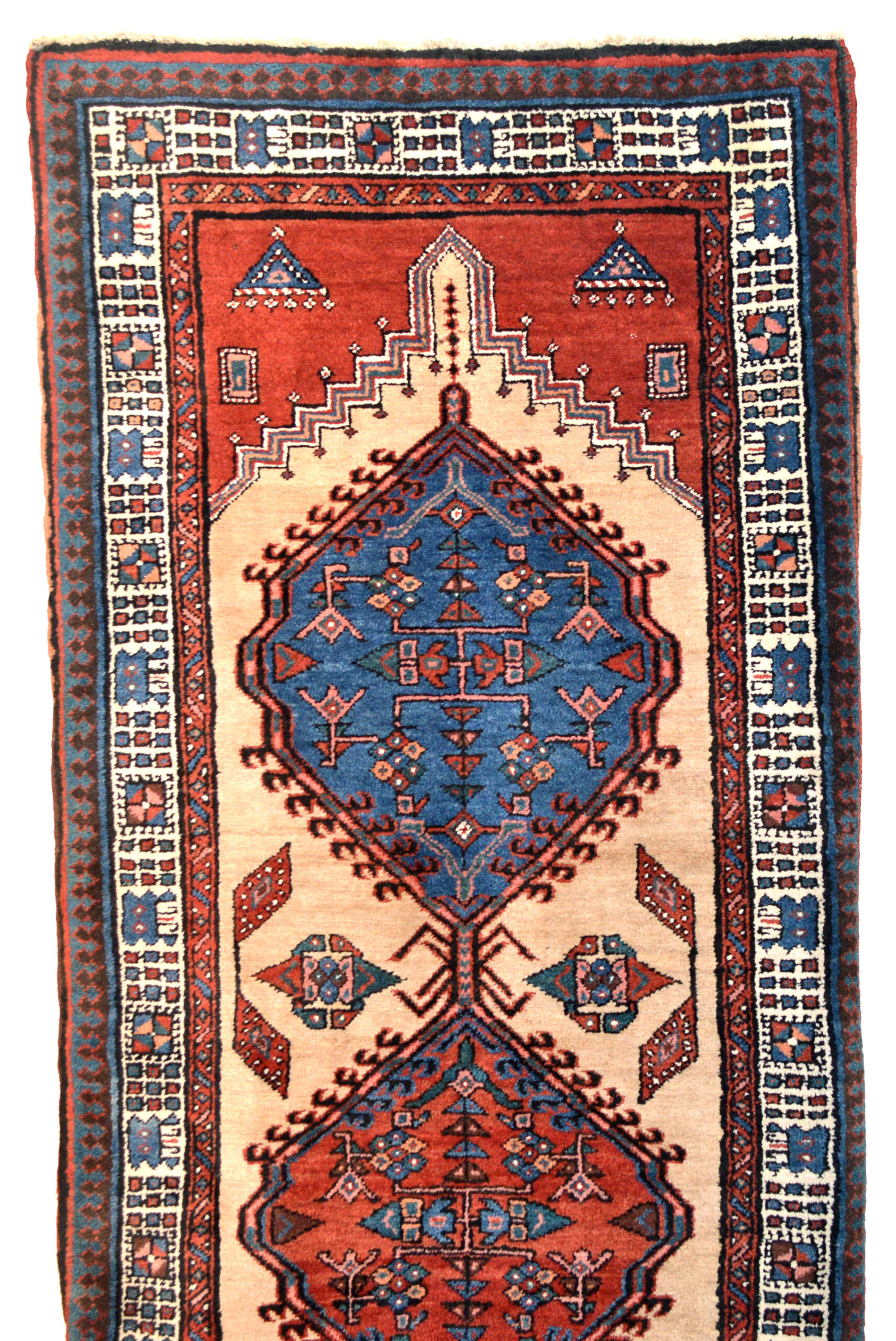 Detail of a vintage Persian Serab runner rug, circa 1930. The light camel color field is decorated with two mid blue medallions and two soft red medallions. An ivory major border and a Reciprocal Trefoil design outer guard border frame the field. Douglas Stock Gallery offers vintage Persian rugs and vintage Oriental rugs for clients in the Boston area, throughout New England, New York and across the United States. We work with individual clients, architects and interior designers for projects utilizing antique rugs and vintage rugs, new farmhouse style interior decor, vintage rugs for modern interiors