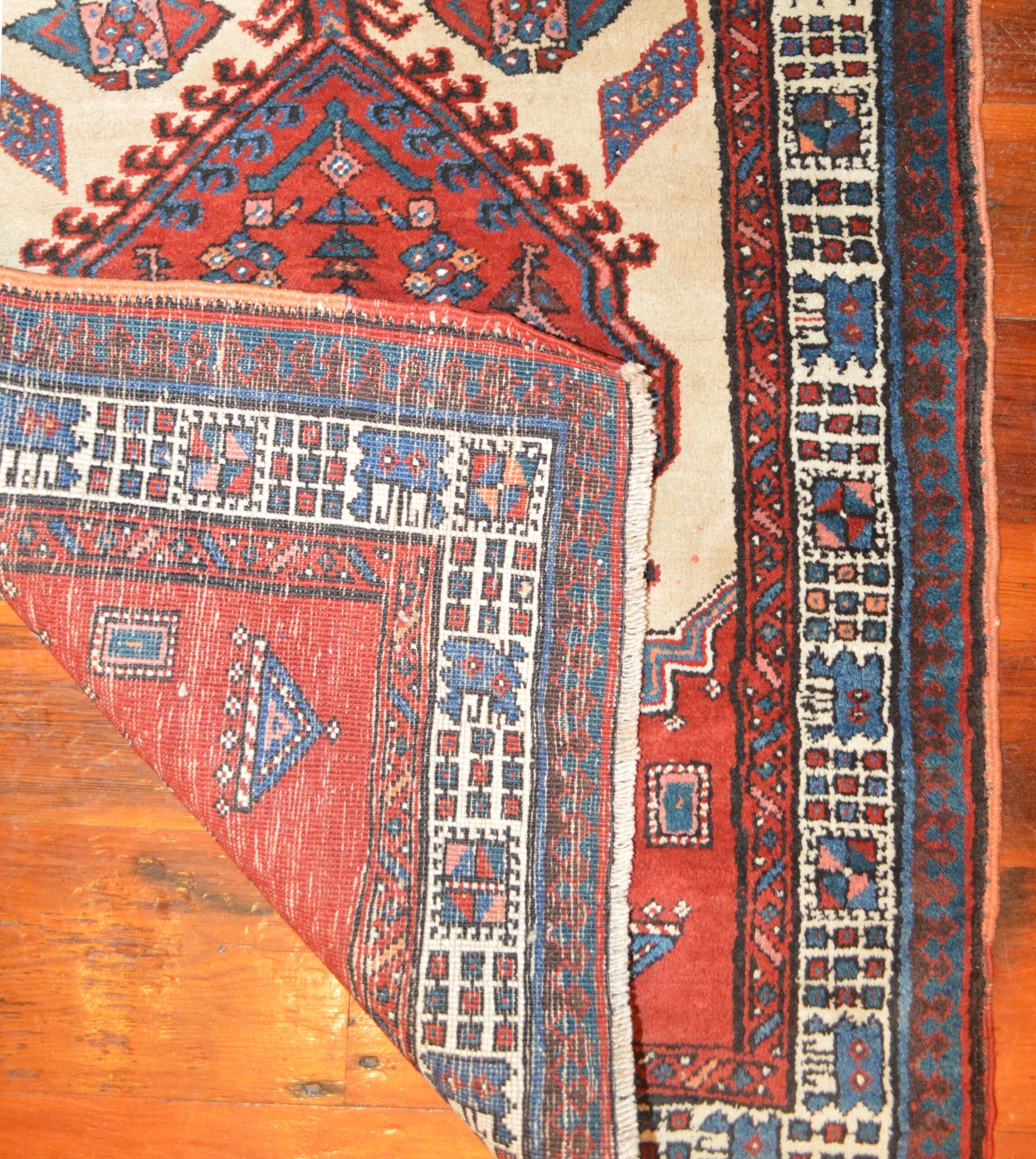 Detail of the weave of a vintage northwest Persian Serab rug, circa 1930. The light camel color field is decorated with two mid blue medallions and two soft red medallions and framed by an ivory major border with a Reciprocal Trefoil outer guard border. Douglas Stock Gallery is a source for vintage and antique Persian runner rugs, Boston,MA area Oriental runner rugs.