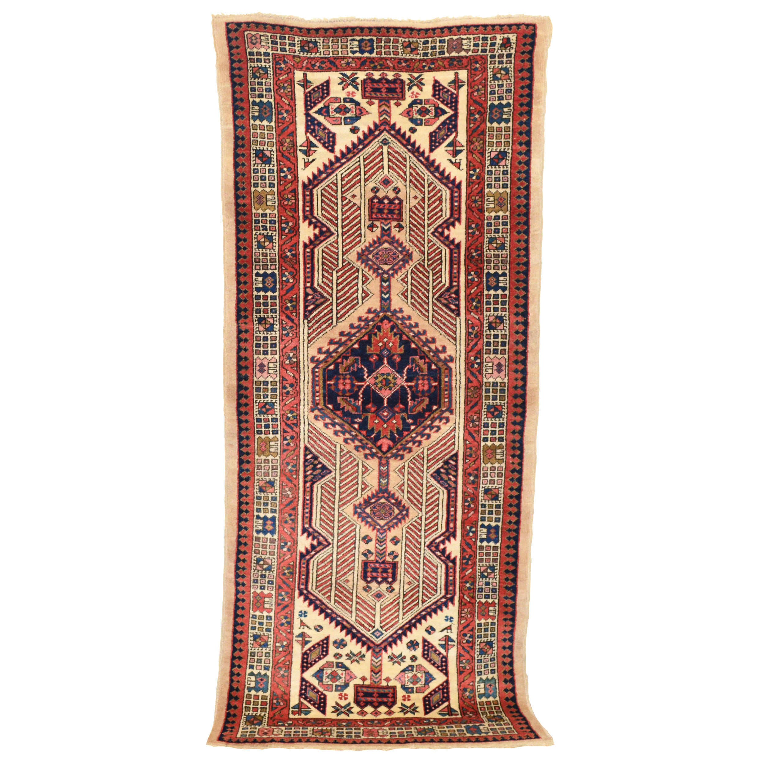 AnAntique Persian Serab long rug (wide and short runner) with a navy medallion on a camel color field that is framed by an ivory border with geometric motifs, circa 1930. Douglas Stock Gallery, antique Oriental rugs Boston,MA area South Natick