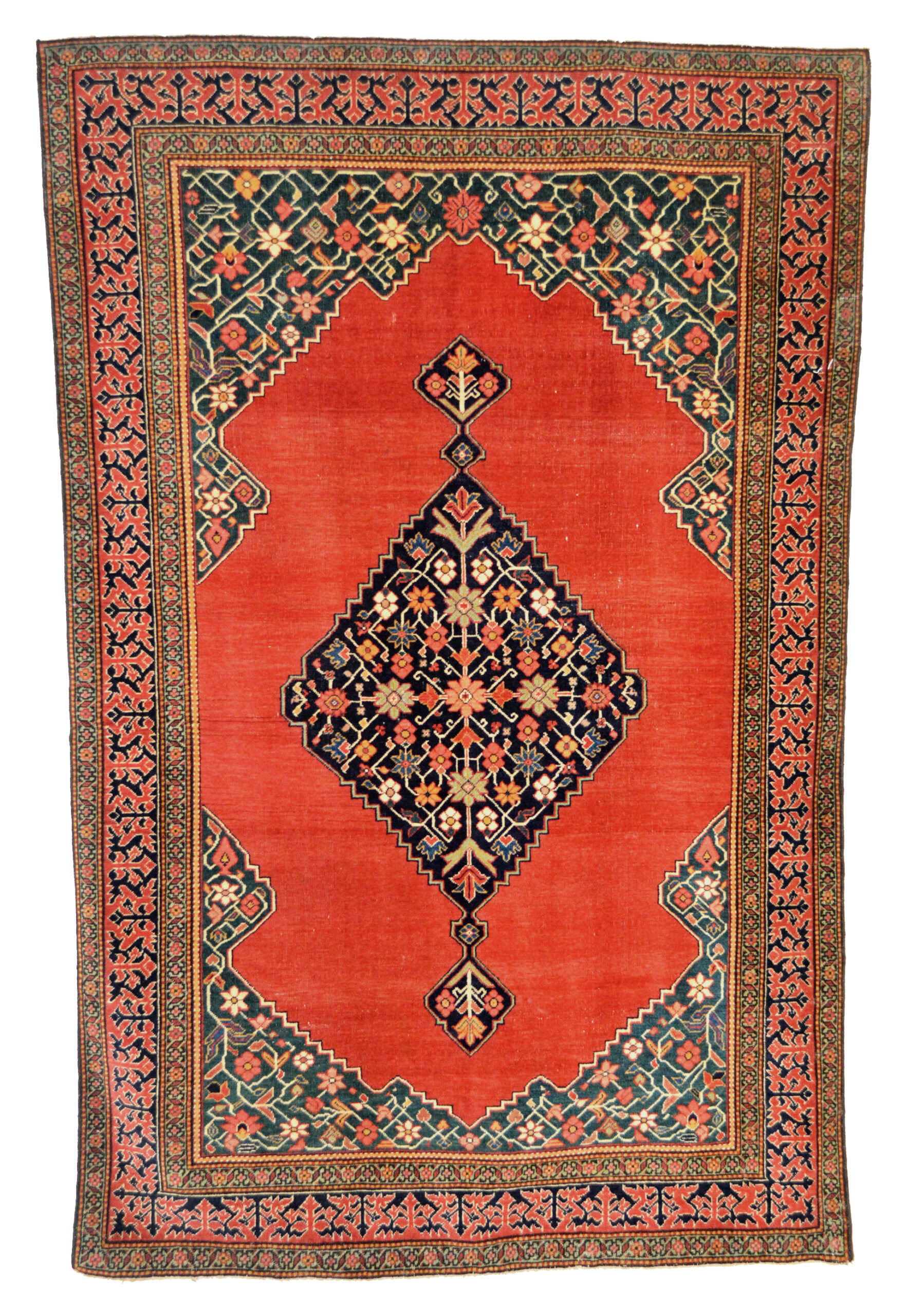 An antique Persian Fereghan rug with a red open field that is decorated with a navy blue medallion and framed by green corner spandrels. Douglas Stock Gallery, antique Oriental rugs and Persian carpets Boston,MA area