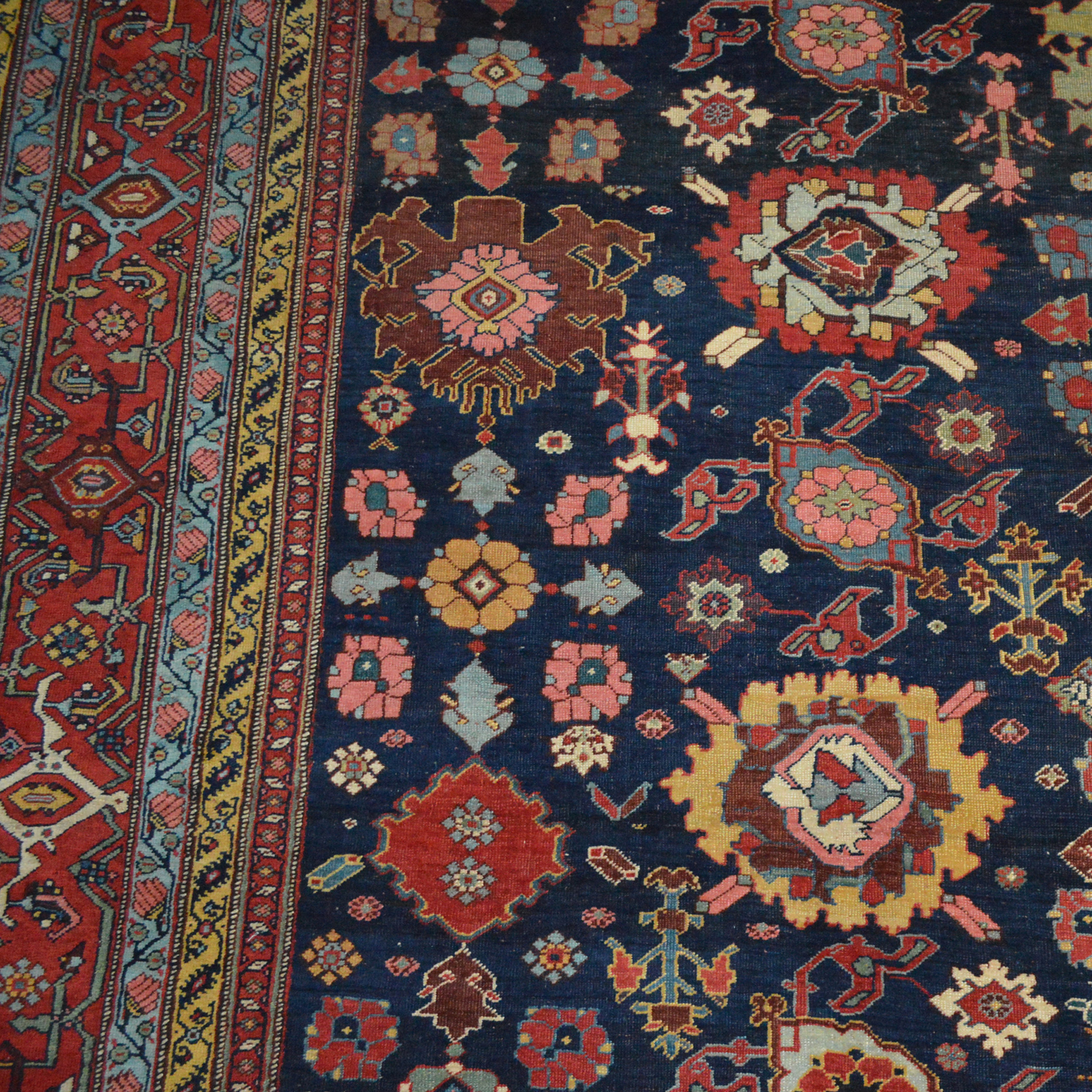 Detail of an antique Persian Bidjar carpet with the classic Harshang design of various palmettes and flowers on a navy blue field, circa 1880. Douglas Stock Gallery is one of America's most selective dealers in antique Persian carpets and other types of antique Oriental rugs, Boston,MA area, South Natick,MA - We work with individual clients, architects and interior designers looking for high quality antique Oriental rugs and offer nationwide shipping.