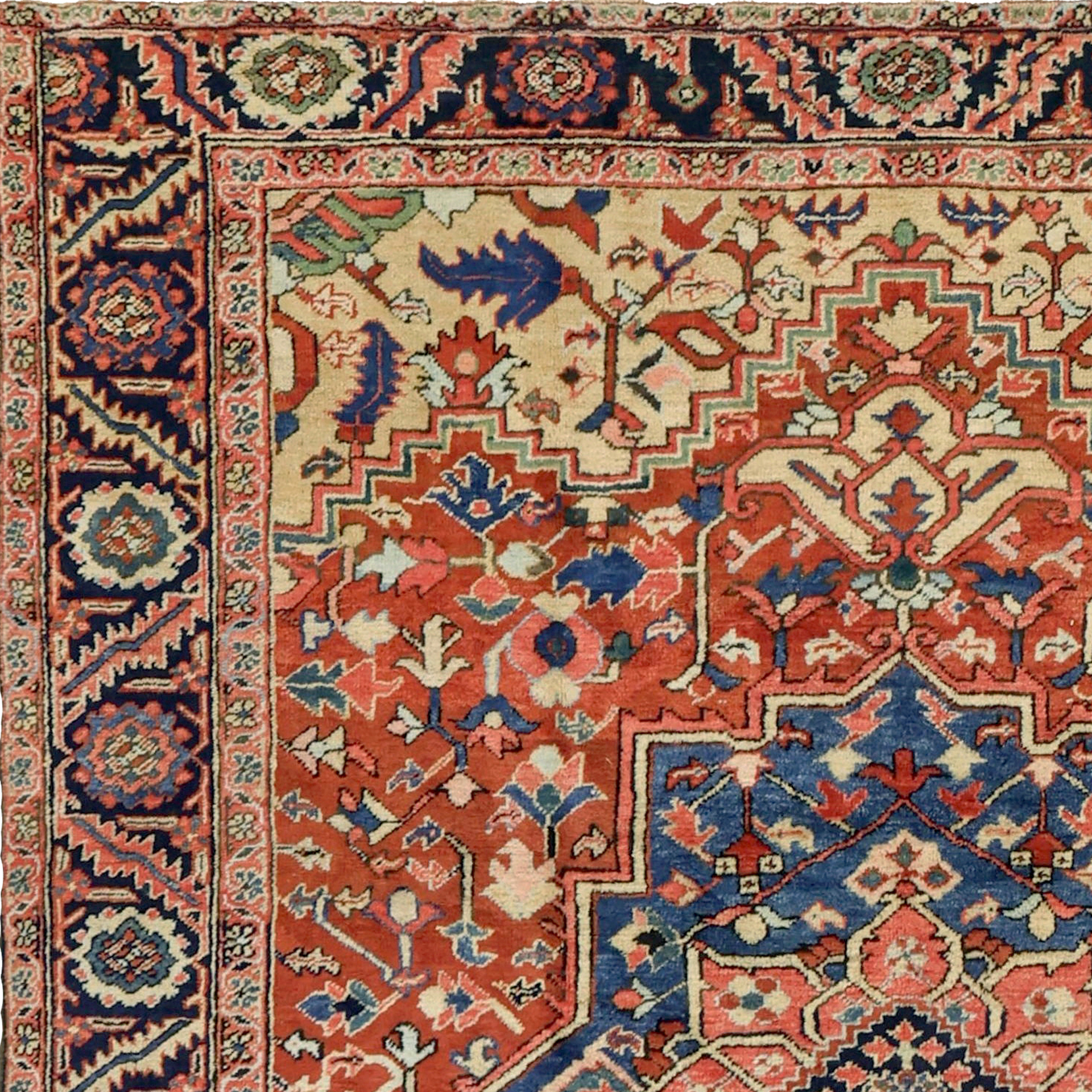 Detail of an antique Persian Heriz carpet with stylized floral forms on a terra cotta color field that is framed by light camel color spandrels and a navy blue border. A denim blue and coral medallion also decorates the field. Douglas Stock Gallery specializes in antique Heriz carpets. Antique carpets Boston,MA area, antique rugs Boston,MA area, antique rugs New York by appointment, antique rugs Washington,DC by appointment