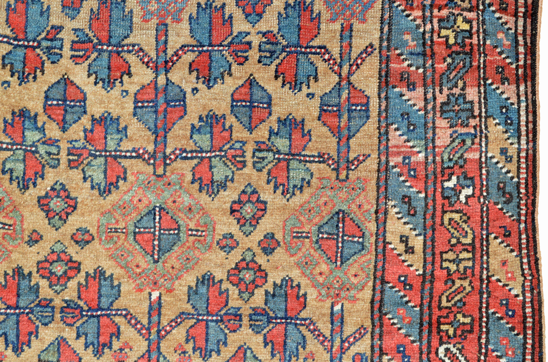 Detail of an antique northwest Persian Kurdish rug with stylized leaves and flowers on a camel color field, circa 1900 - Douglas Stock Gallery, antique tribal rugs Boston,MA area New England, antique tribal rugs New York by appointment