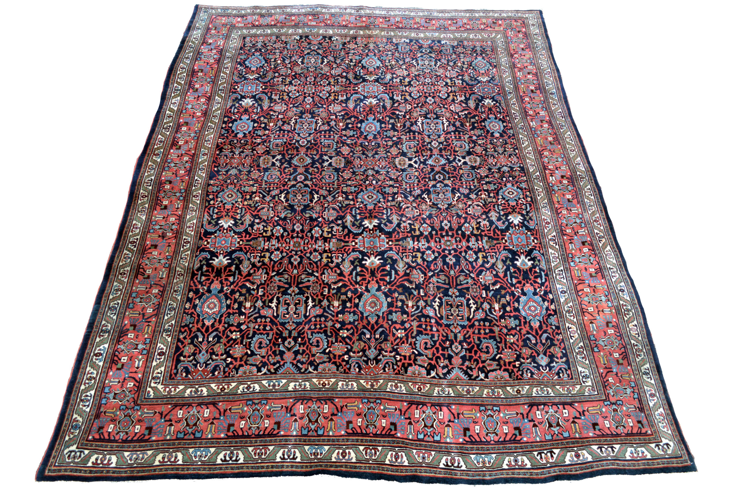 An antique Bidjar carpet with palmettes, vines, flowers and leaves on a navy blue field. A coral border with ivory and green guard borders frames the field, northwest Persia, circa 1915. Douglas Stock Gallery is one of America's leading specialist dealers in antique Persian Bidjar rugs and carpets and other antique Kurdish rugs including antique Senneh rugs and antique Kurdish nomadic and village rugs. Antique Oriental rugs Boston Beacon Hill, Boston Back Bay, Brookline, Newton, Weston, Belmont, Concord, Wellesley, Natick,MA area