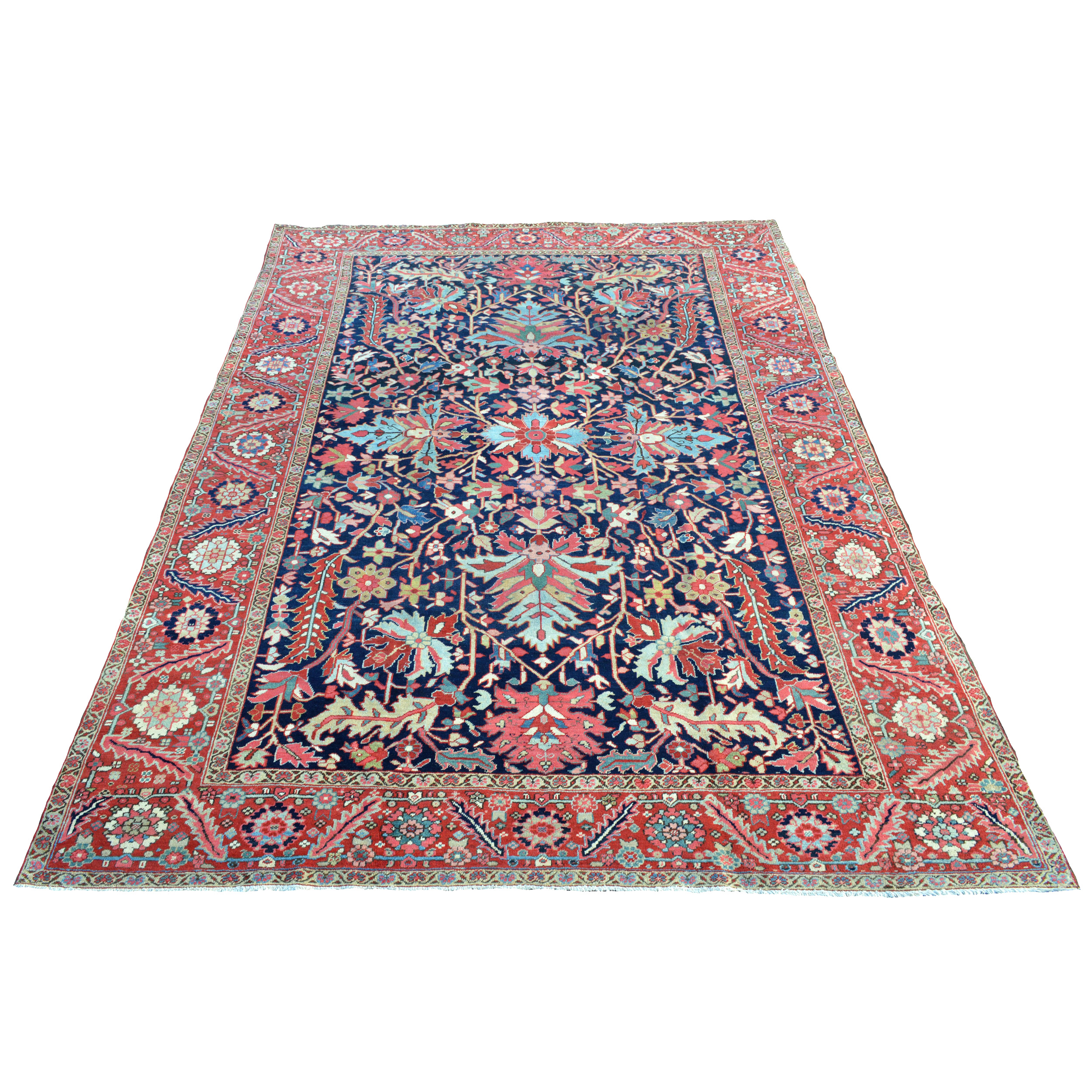 An antique Persian Heriz carpet, circa 1910, with large, polychromatic palmettes, leaves and ancillary stylized floral motifs on a navy blue field. A brick red border with flowerheads and leaves frames the field. Douglas Stock Gallery is one of America's most respected dealers in antique Persian carpets. Antique rugs Boston,MA area