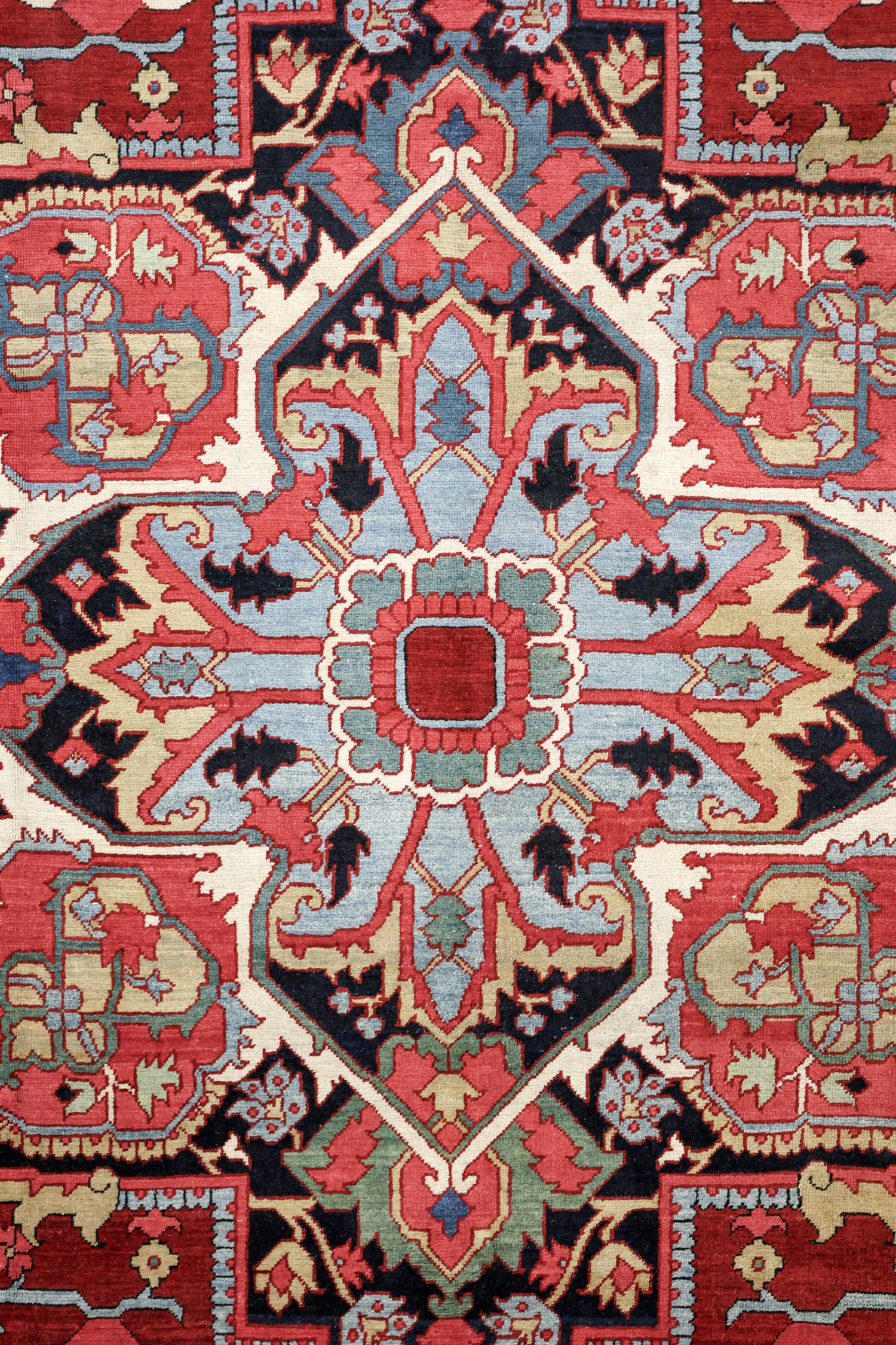 Detail of the central medallion in an antique Persian Heriz carpet, circa 1900. The navy medallion has a green and sky blue center with greenish-yellow, coral, green and ivory highlights. Douglas Stock Gallery, antique Heriz carpet Boston,MA area