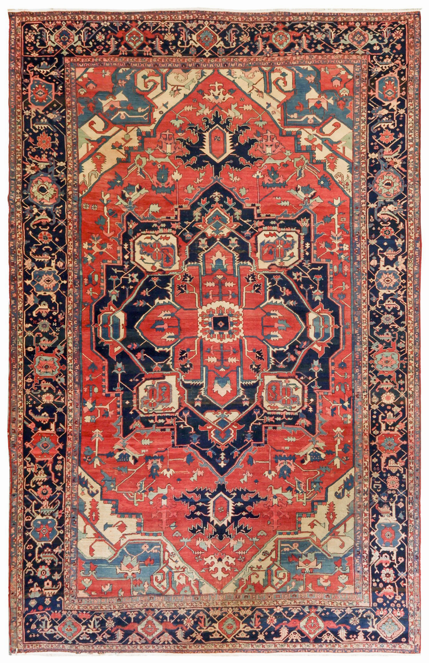 A large antique Heriz "Serapi" carpet with a navy blue medallion on a salmon color field that is framed by ivory corner spandrels and a navy blue border, northwest Persia, circa 1890