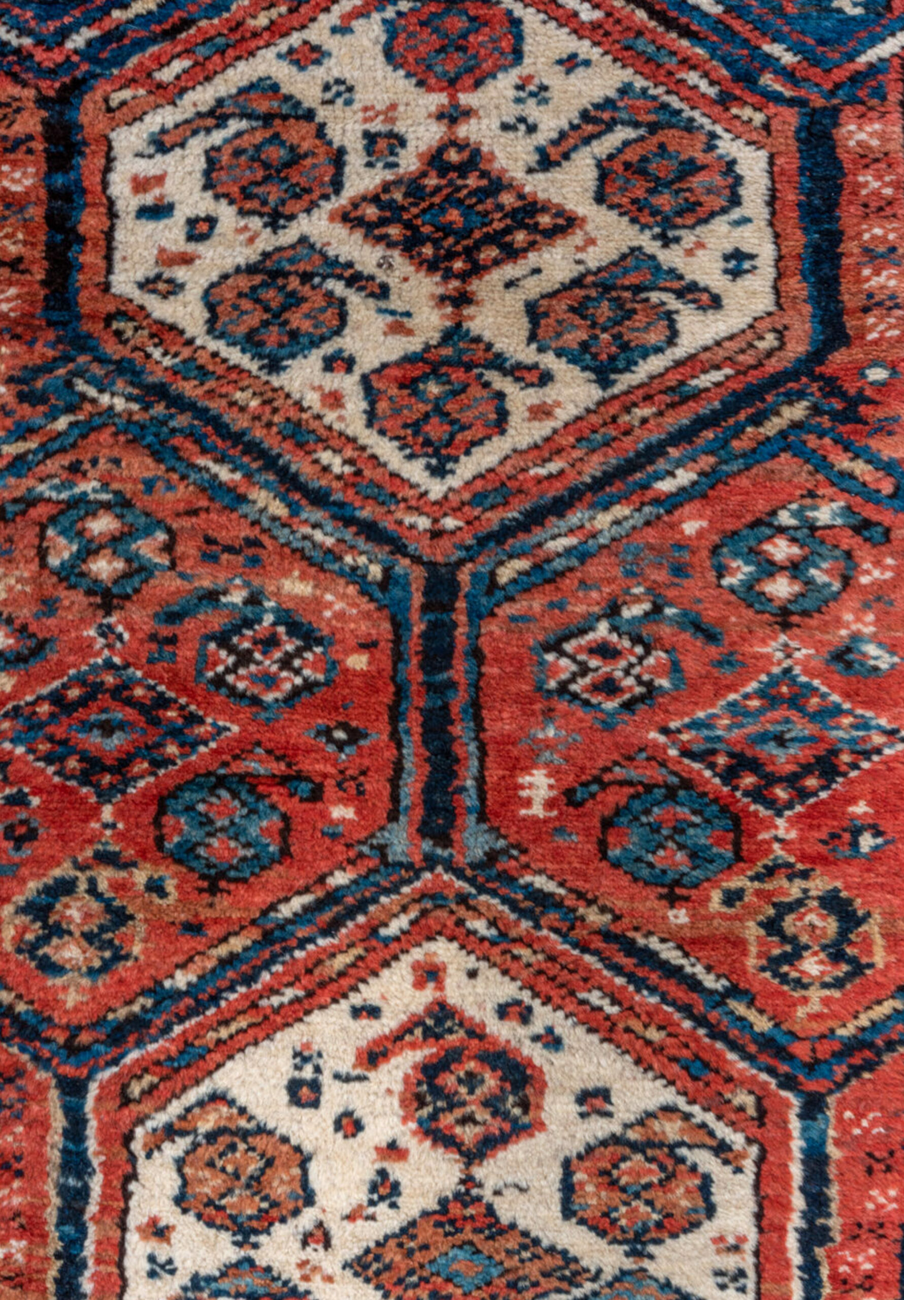 Field design from an antique Persian Luri tribal rug with ivory medallions on a brick red and navy blue field, circa 1900. Douglas Stock Gallery is a Boston area dealer offering high quality antique Persian tribal rugs including examples by QashQa'i. :uri, Kurdish, Afshar and Bakhtiari people.