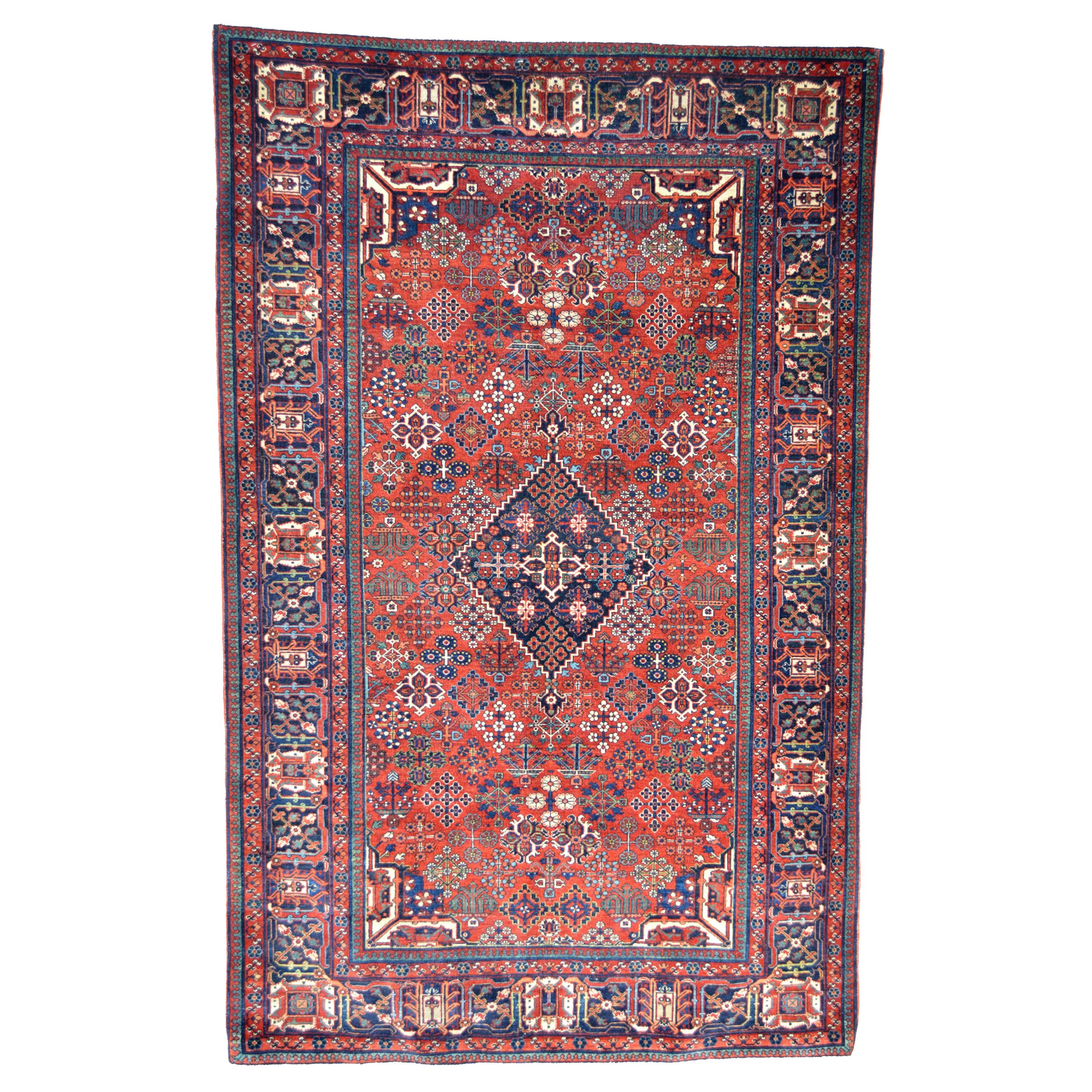 Antique central Persian Joshagan rug, circa 1920, with a salmon color field decorated with Quatrefoil motifs and stylized flowers and framed by a navy blue border. Douglas Stock Galery, antique Oriental rugs Boston,MA area, antique rugs Brookline, Newton, Wellesley, Weston, Concord, Natick,MA area New England