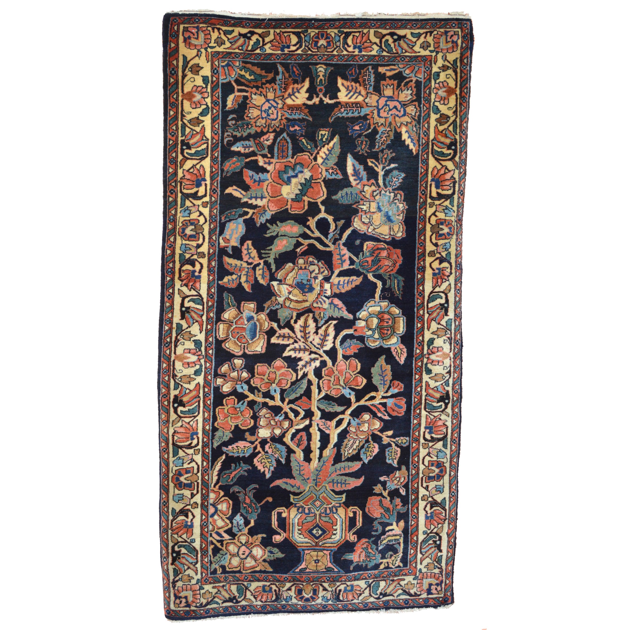 Antique Sarouk rug with a vase and large flowers and leaves on a navy blue field. A light yellow border frames the field, central Persia, circa 1925 - Douglas Stock Gallery
