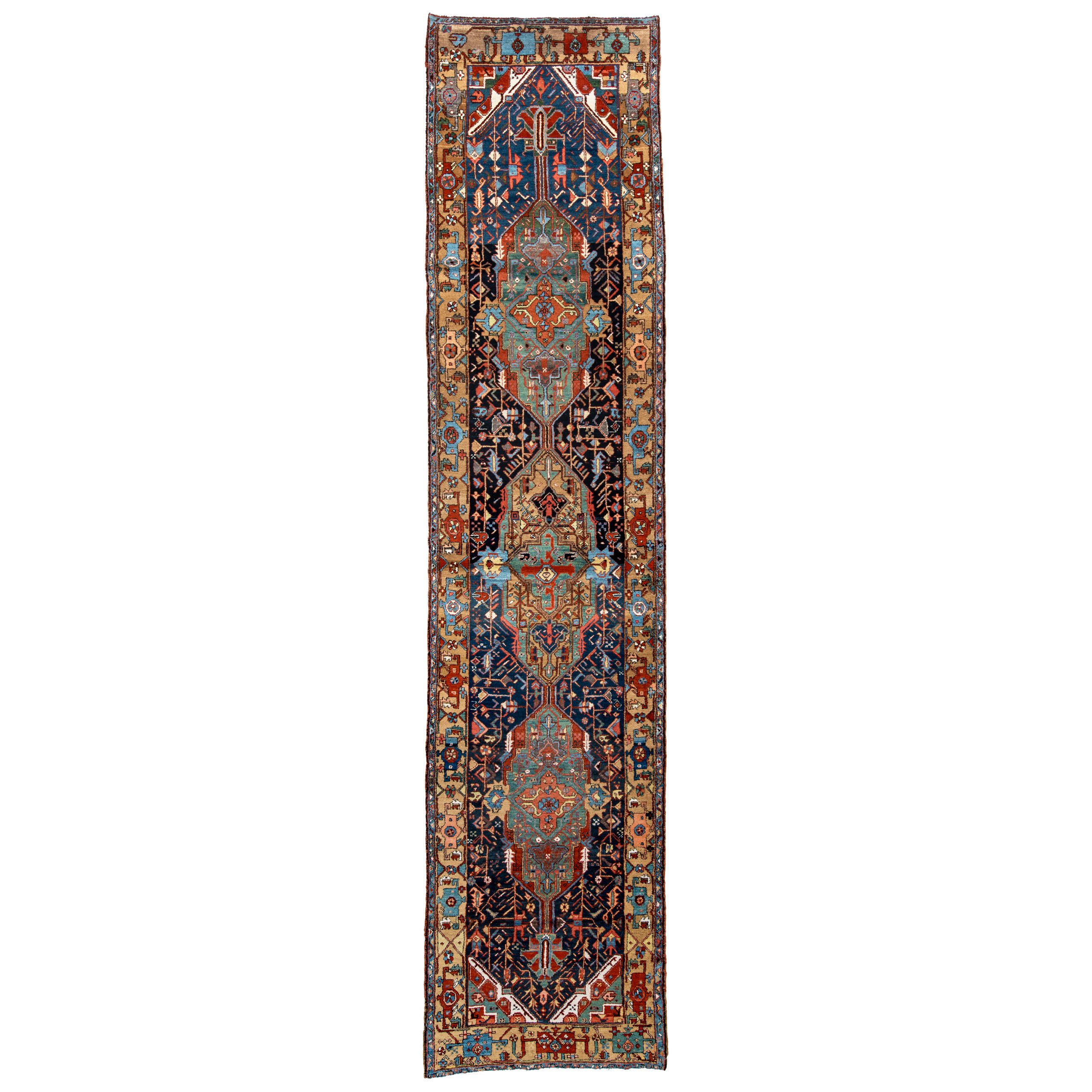 Antique Karaja "Serapi" runner from the Heriz area in northwest Persia. The navy blue field is decorated with two green medallions and one camel color medallion and framed by a camel color border. Douglas Stock Gallery, antique Persian runner rugs