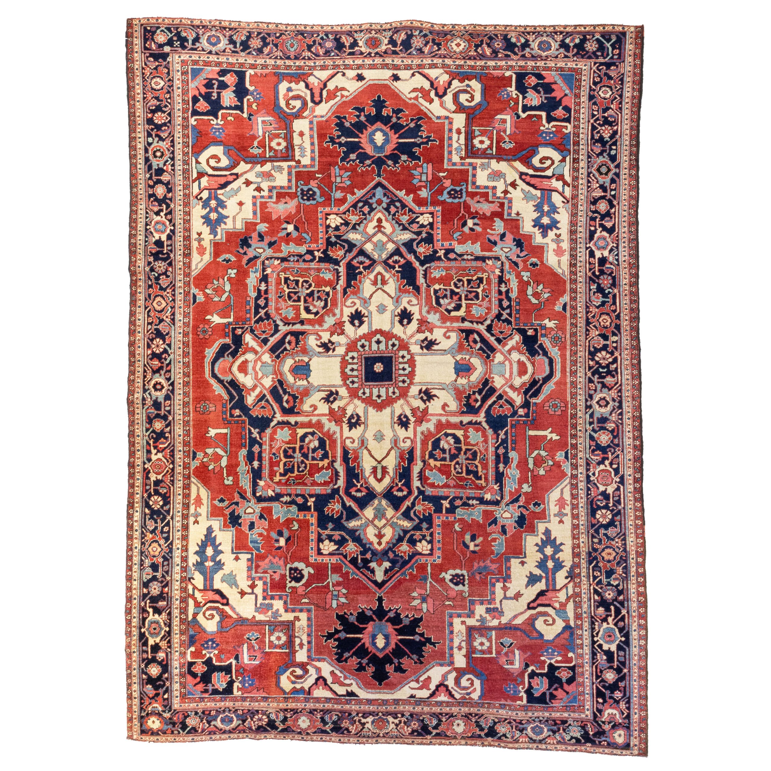An antique Heriz "Serapi" carpet with a navy blue and ivory medallion on a salmon field that is framed by ivory corner spandrels and a navy blue border, northwest Persia, circa 1900 - Douglas Stock Gallery offers a carefully curated selection of antique Heriz area rugs and room size carpets, including antique Heriz, Karaja "Serapi" and Bakshaish carpets, antique carpets Boston, Brooklin,e Newton, Wellesley, Natick