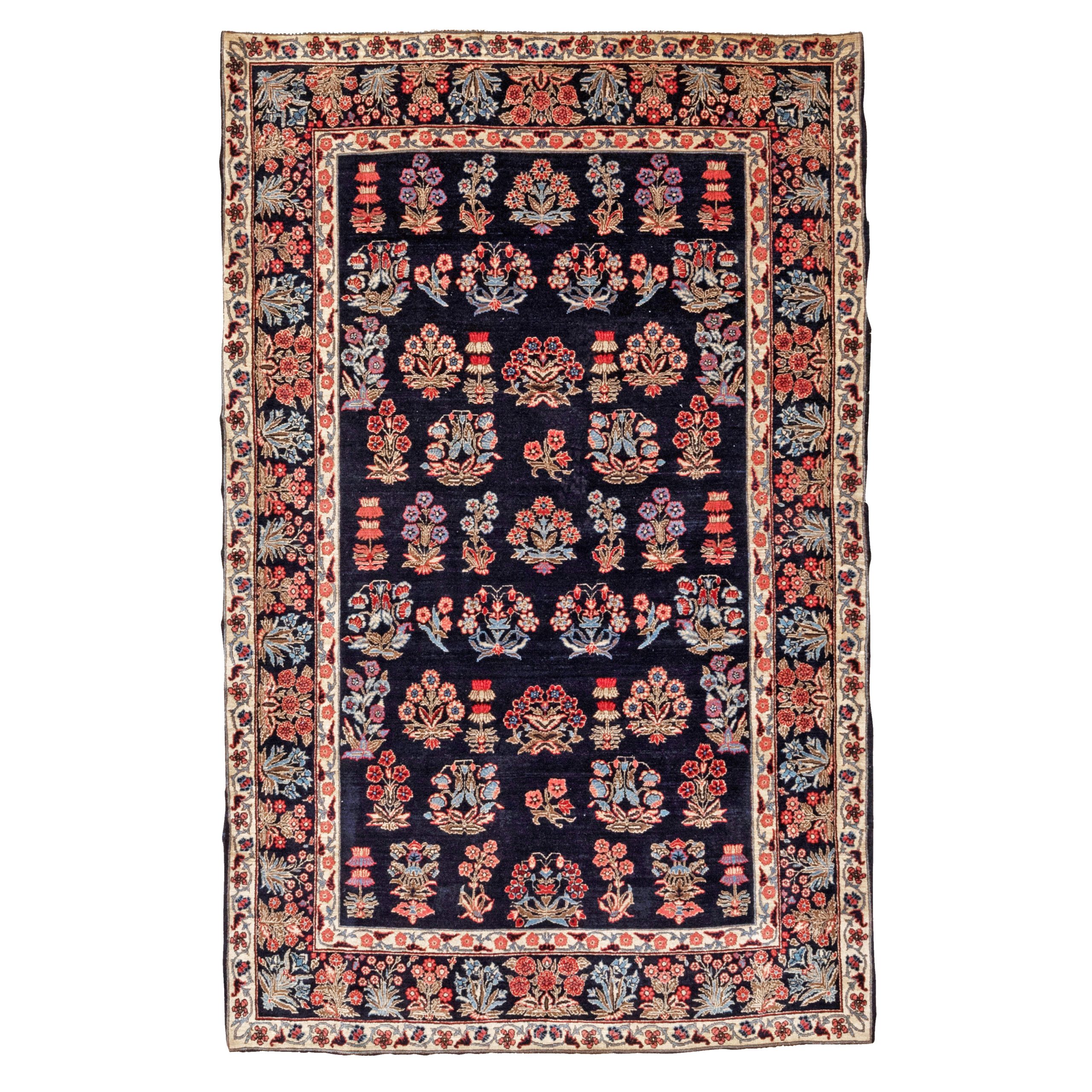 A very finely woven and highly distinctive antique Sarouk rug, seemingly woven around the time of the transition from the Fereghan Sarouk style to the Mahajaran Sarouk style, circa 1915. The navy field is decorated with various floral forms and framed by a navy border with flowers or shrubs. Douglas Stock Gallery specializes in antique Persian Sarouk rugs, Fereghan Sarouk rugs and Mahajaran Sarouk rugs. Antique Sarouk rugs Boston,MA area New England, antique Sarouk rugs New York by appointment, antique Sarouk rugs Washington,DC area by appointment