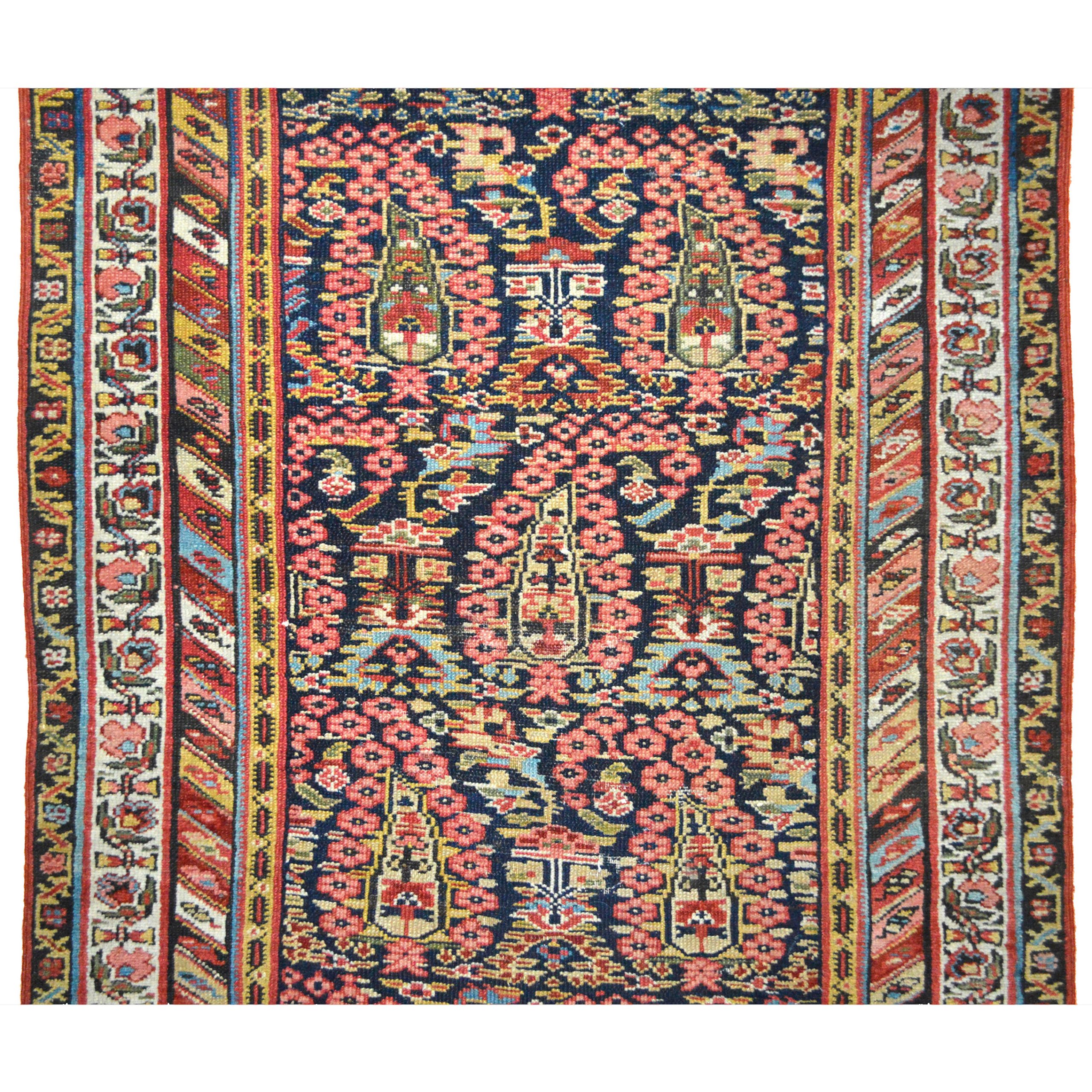 An antique Persian village runner rug with complex "Boteh" (Paisley shape motifs) on a navy blue field that is framed by a multi color diagonal stripe border, west or northwest Persia, circa 1900. Douglas Stock Gallery offers a carefully curated selection of antique Persian runner rugs, antique Persian runner rugs Boston,MA area