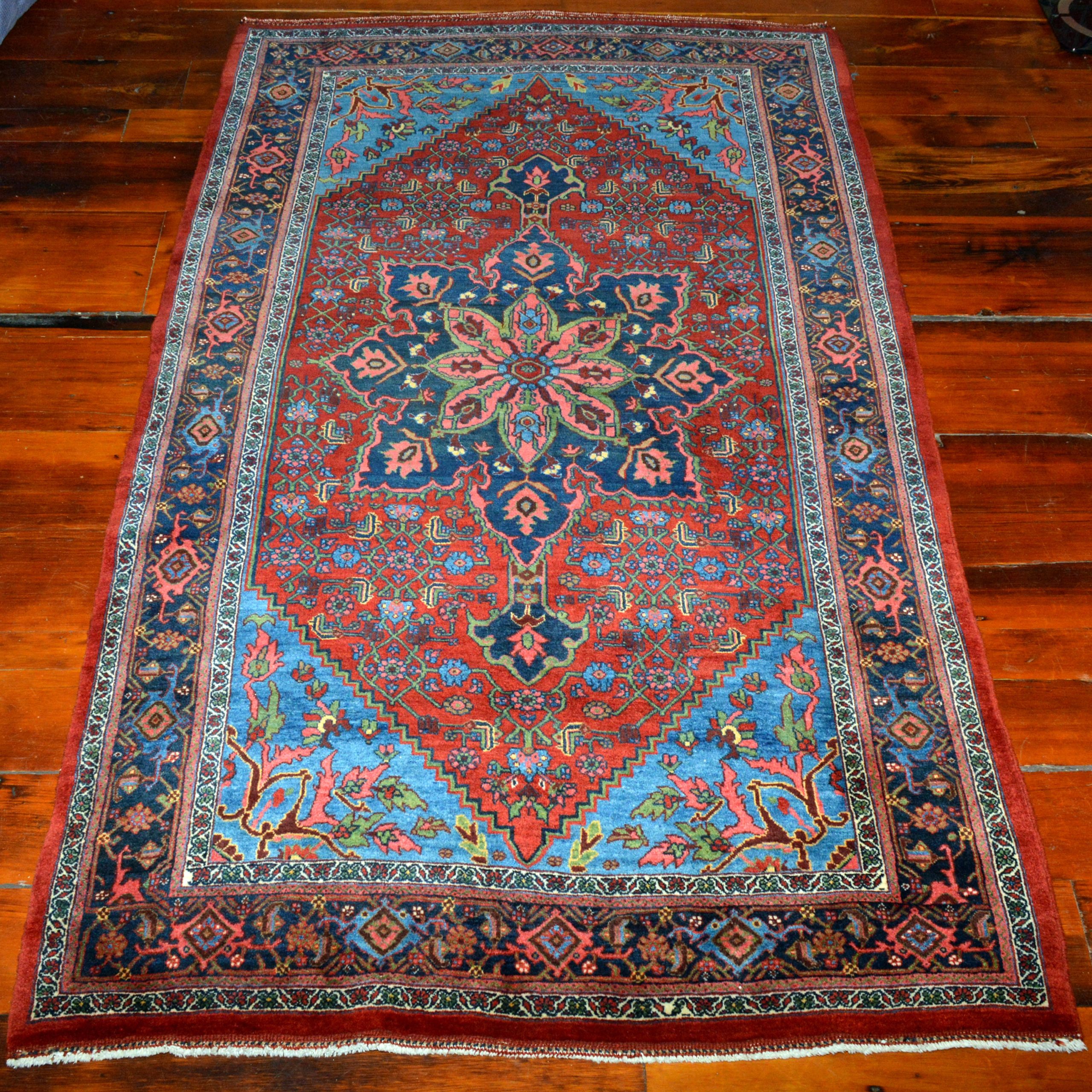 Of uncommon size, abouot one foot longer than a more standard "dozar" size Bidjar rug, this antique Bidjar rug features an eight point navy blue medallion on a red field that is decorated with the classical "Herati" design. Sky blue corner spandrels with stylized leaves and flowers and a navy blue "Turtle" design border frame the field, northwest Persia, Kurdistan province, circa 1920. Douglas Stock Gallery is one of America's leading dealers in antique Persian Bidjar rugs, antique Bidjar rugs Boston,MA area New England, antique Bidjar rugs NYC by appointment, antique Bidjar rugs Washington DC area by appointment